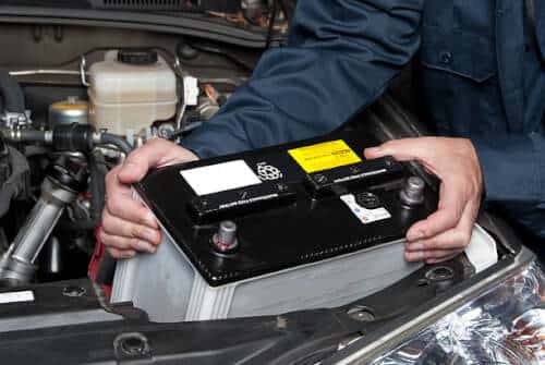 Un meccanico sostituisce una batteria auto